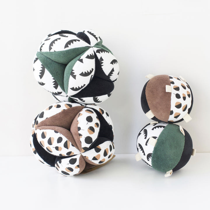 Stacked montessori balls, two clutch balls and two taggy balls stacked up.