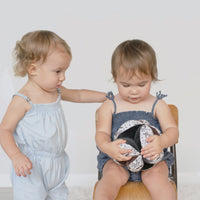 two toddler girls playing with clutch ball